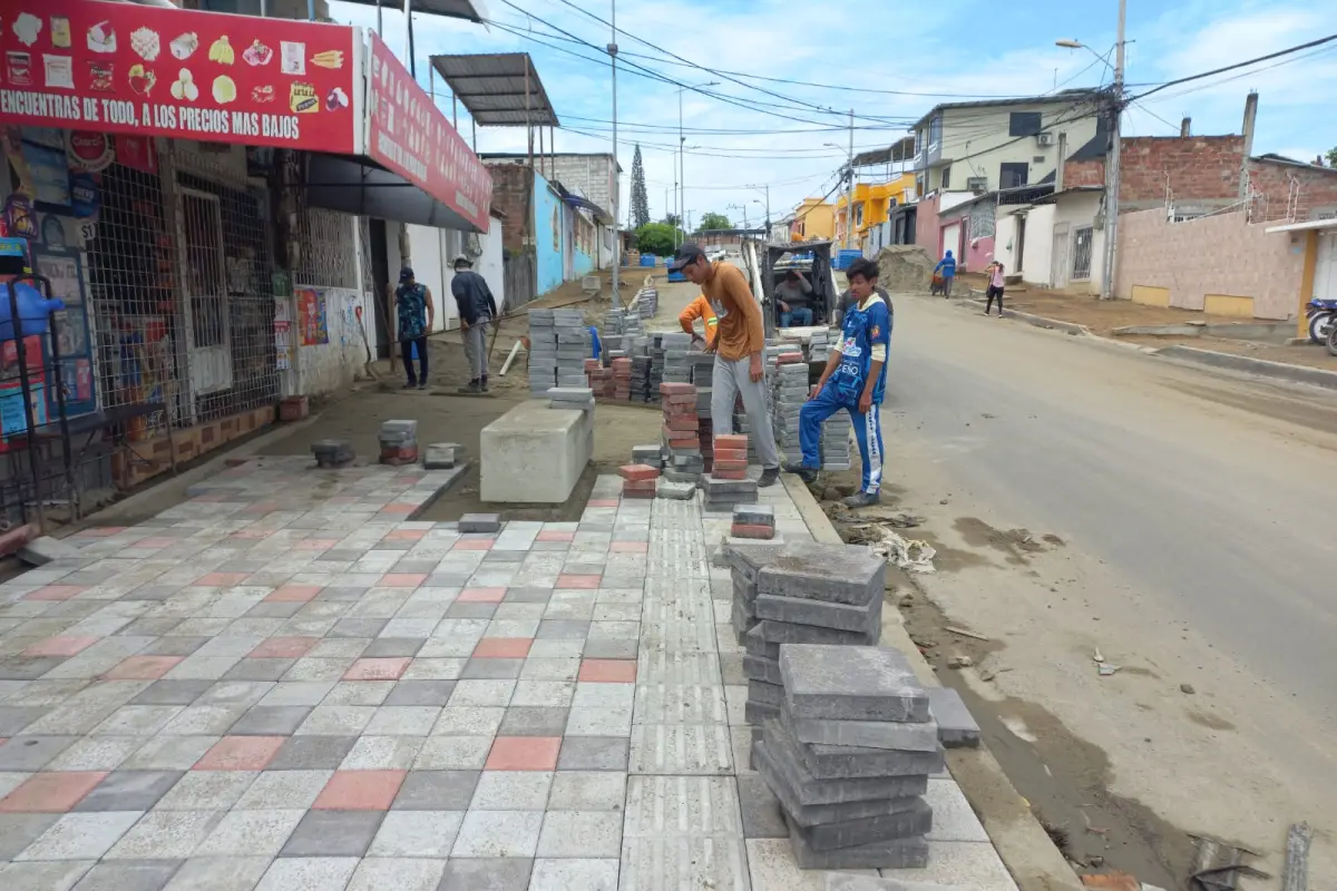Obreros trabajando en la instalación de adoquines en la calle 321 de la parroquia Eloy Alfaro.