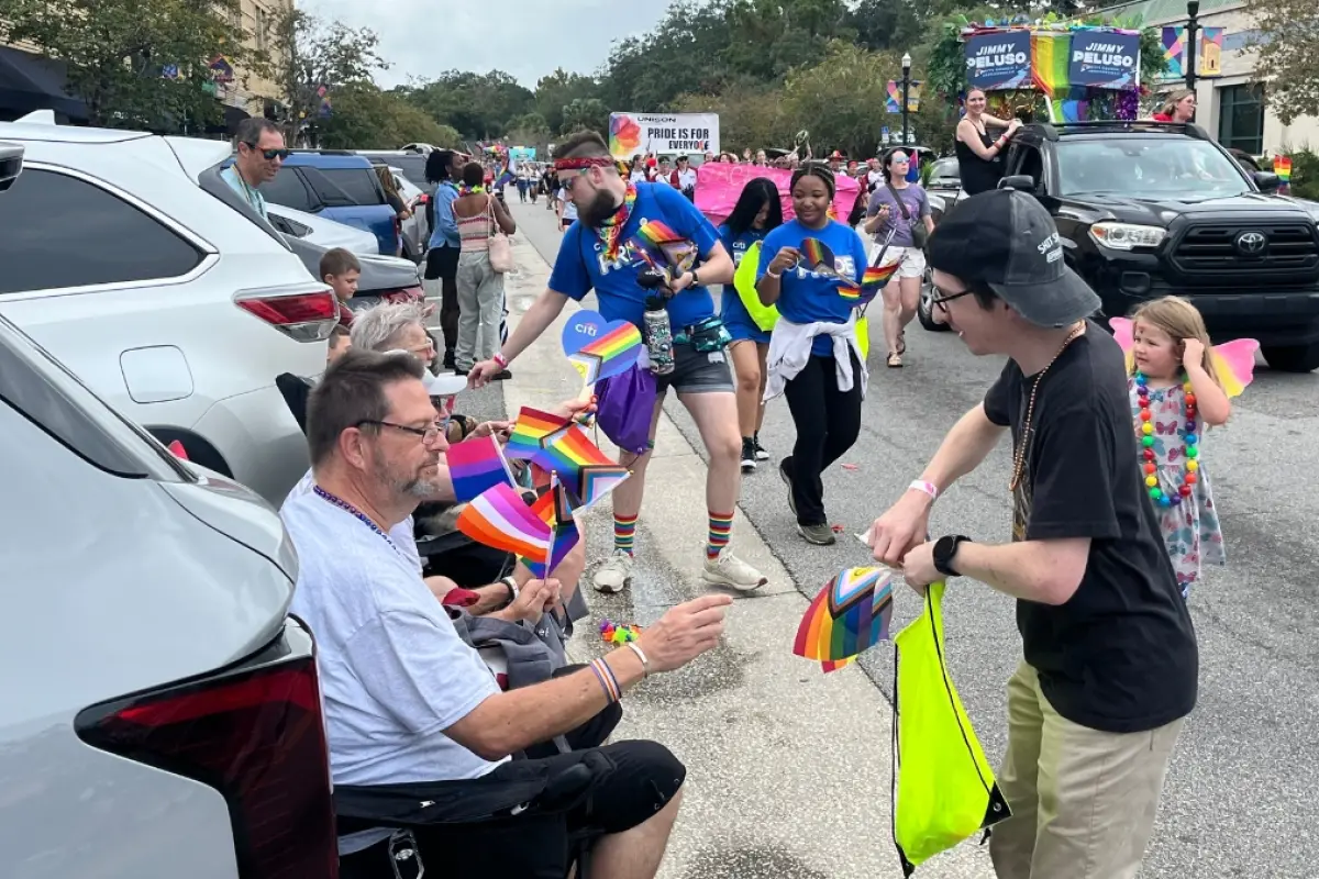 Jacksonville se pintó de arcoíris orgullo, memoria y migrantes mirando desde la acera., 