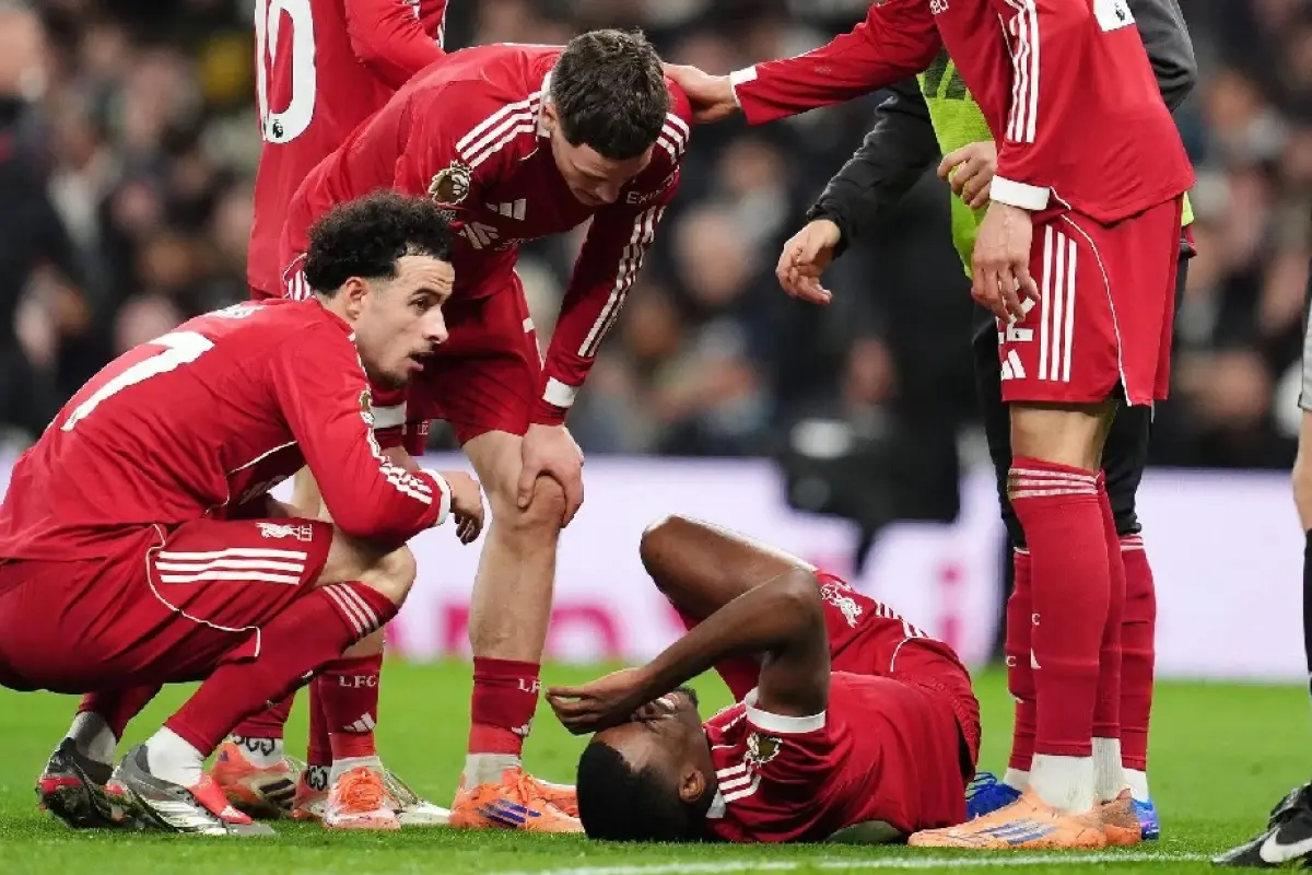 Alexander Isak, tirado en el suelo mientras era consolado por sus compañeros del Liverpool.