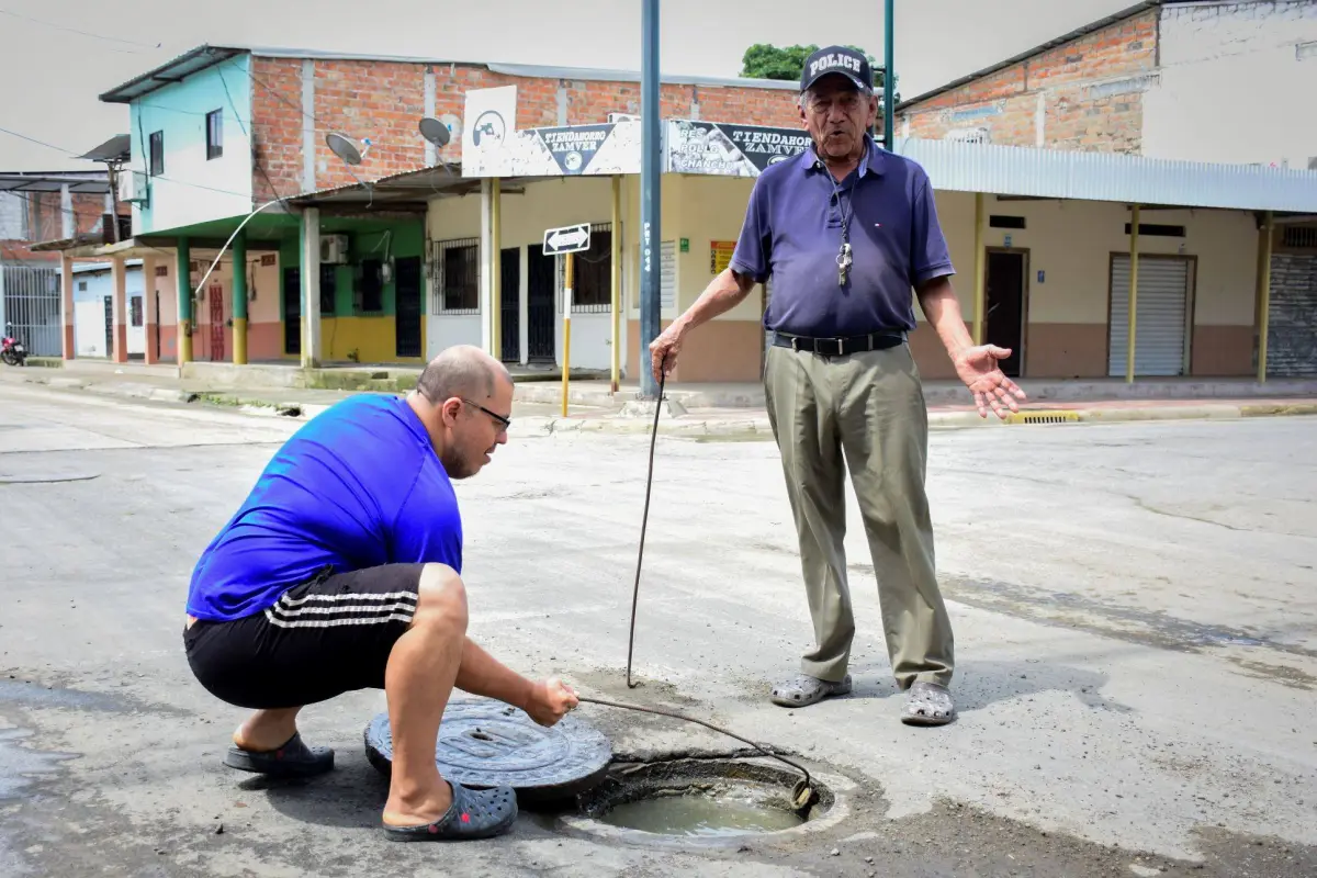 Alejandro Cevallos y Darwin Mosquera, habitantes de la calle Cristo Rey y Baquerizo Moreno, muestran una de las alcantarillas colapsadas., El Diario