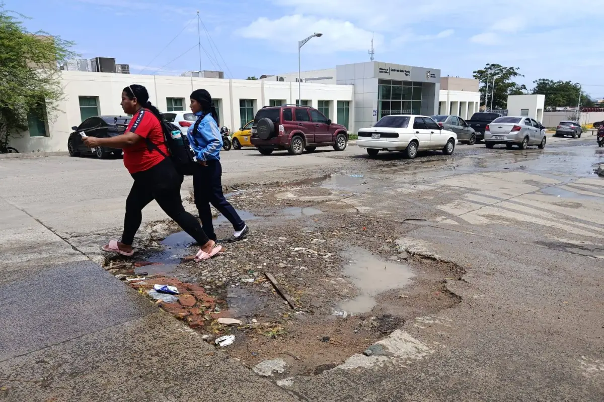 Transeúntes sortean el hueco en la calle 14 y avenida 32; EP Aguas de Manta ofreció reponer el material de la calle., El Diario