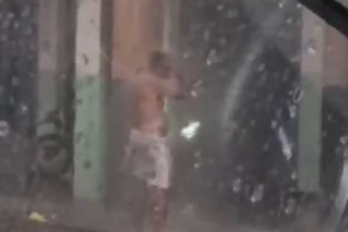 Un hombre se baña bajo la lluvia en Guayaquil