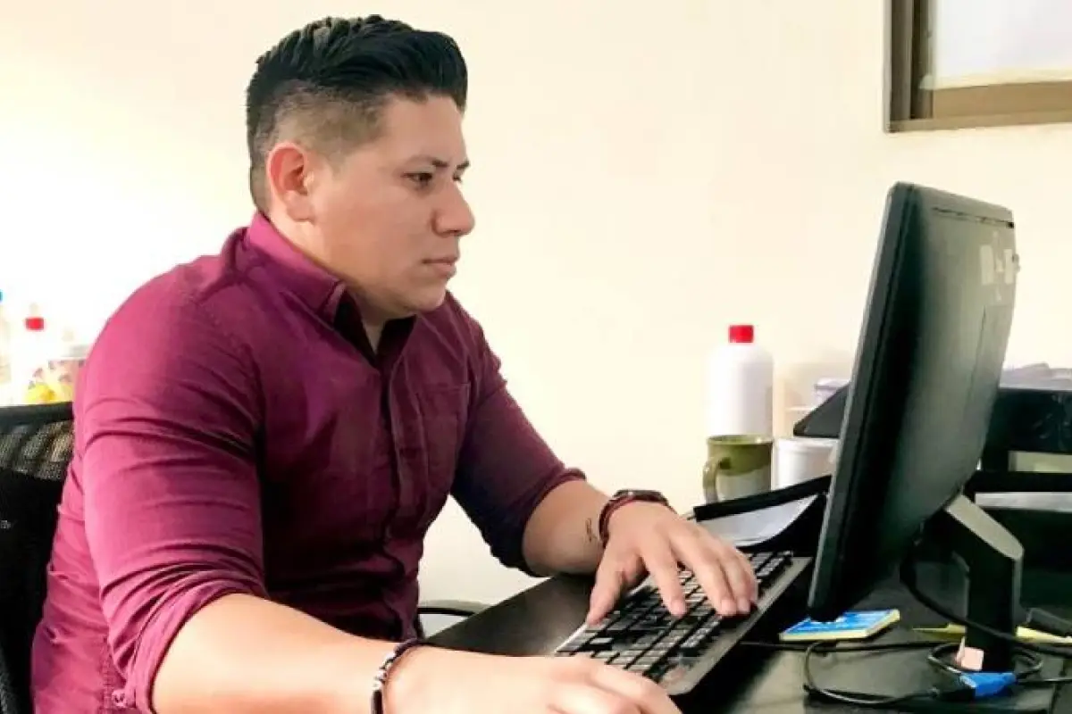 Estudiante adulto accede a educación a distancia gratuita en Ecuador desde computador.