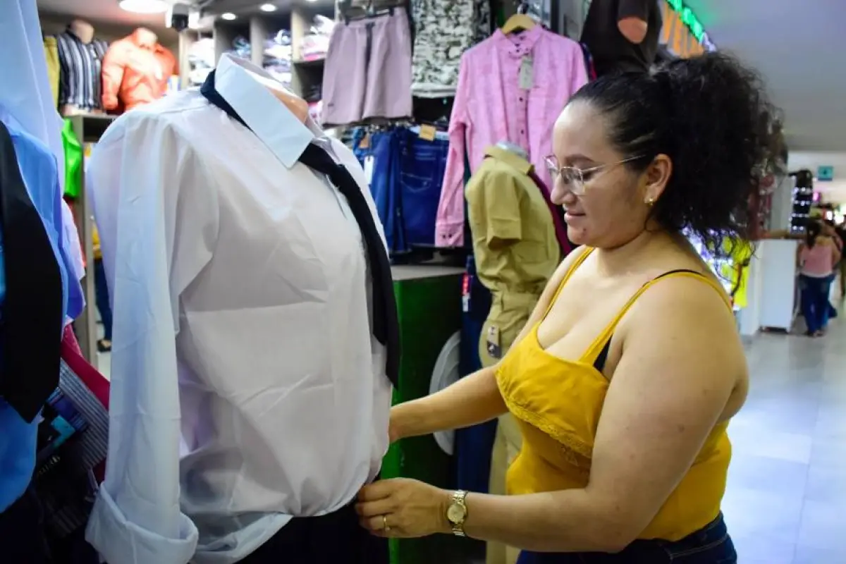  Liliana Dela organiza los uniformes que exhibe en su negocio en el CC1. , El Diario.