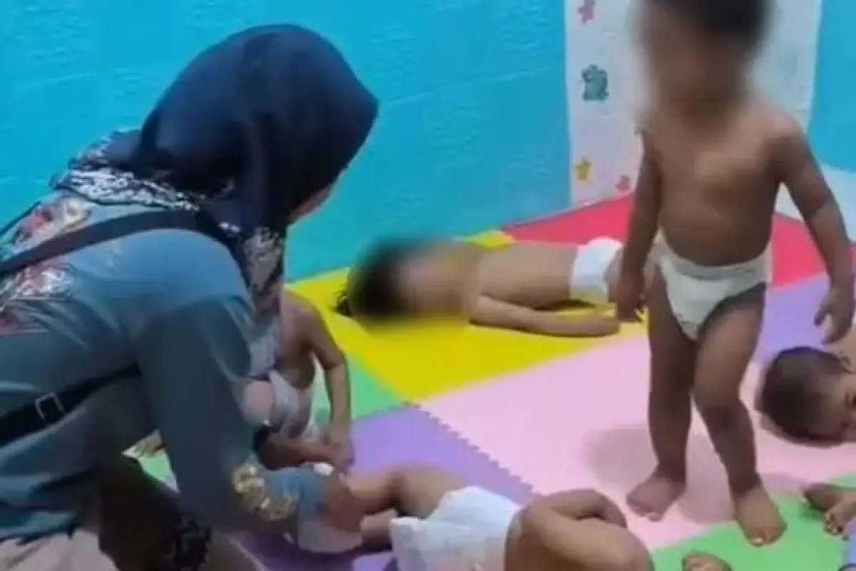 Una agente de Policía especializada en menores le suelta las piernas a uno de los menores a quien habían atado., Foto: Agencias