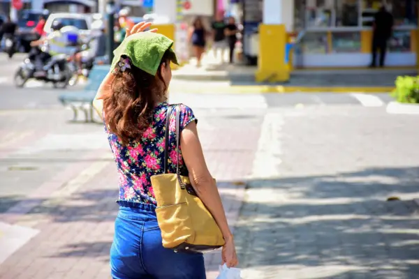 Ciudadanos buscan protegerse del sol ante las altas temperaturas registradas durante junio en Portoviejo.