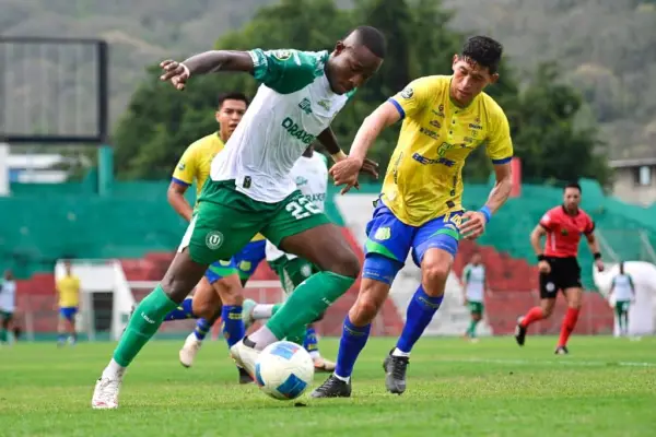 Camilo González, de Liga de Portoviejo, intenta superar a un jugador de Gualaceo