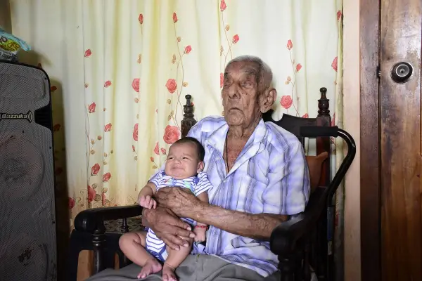 Juan María Zambrano sostiene en sus brazos a su bisnieto Santiago, de dos meses de edad.