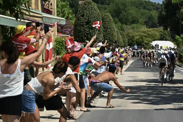 Los espectadores animan al grupo de ciclistas (pelotón) en la localidad de La Roque-Gageac durante la octava etapa de la 113.ª edición del Tour de Francia —un recorrido de 180,4 km entre Périgueux y Bergerac, en el suroeste de Francia. ,LOIC VENANCE / AFP