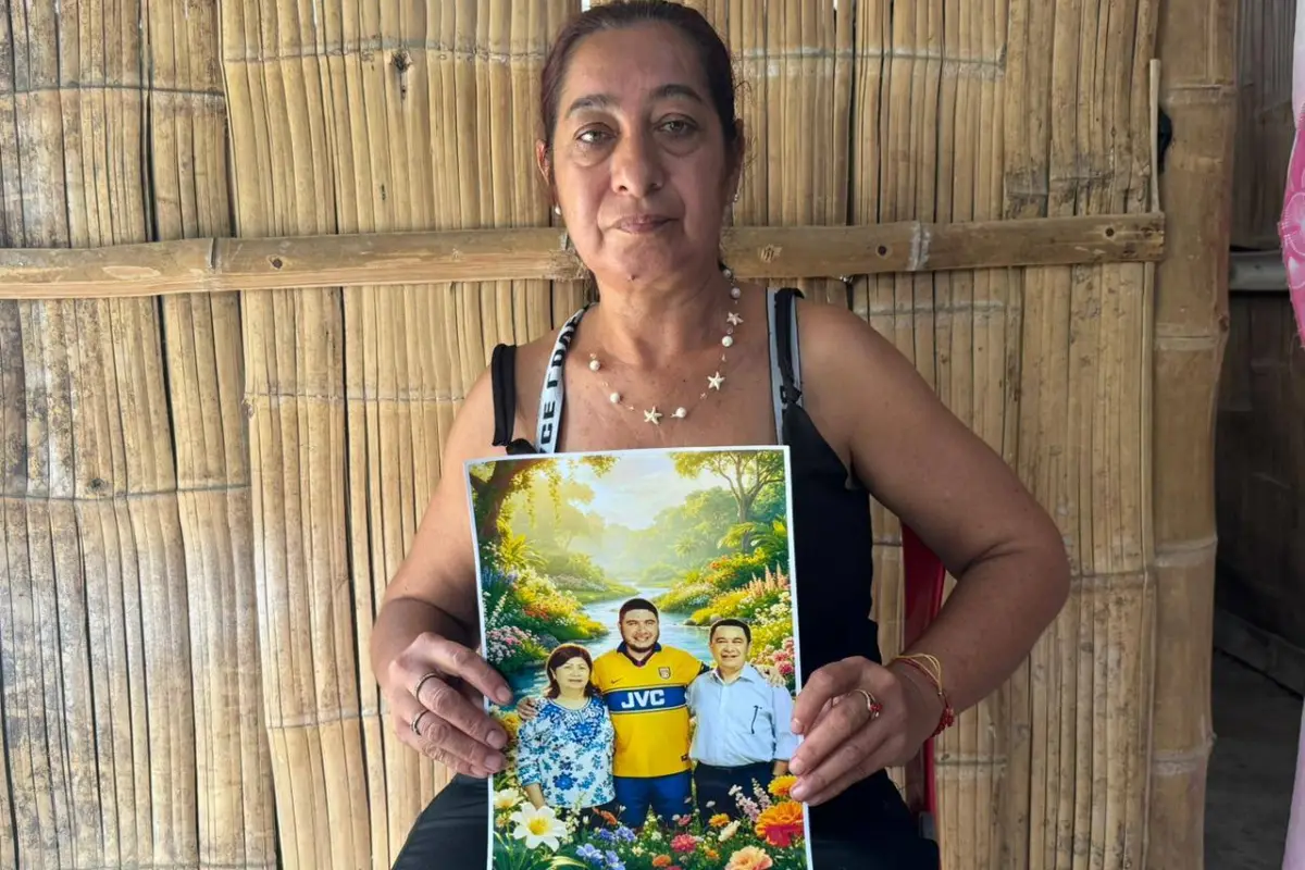 Mariuxi Ruiz sostiene la fotografía de su padre, su hermano y su comadre, quienes fallecieron durante el terremoto en Venezuela.