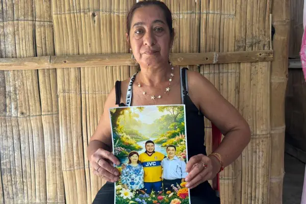 Mariuxi Ruiz sostiene la fotografía de su padre, su hermano y su comadre, quienes fallecieron durante el terremoto en Venezuela.