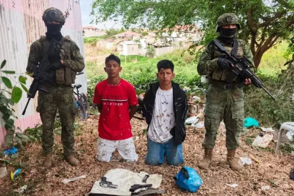 Los dos sospechosos junto a las armas decomisadas como parte del operativo de elementos militares. ,Foto: Fuerzas Armadas